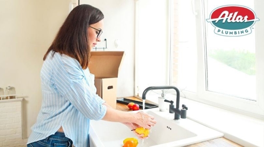 woman washing fruit at sink