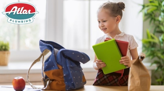 Little girl packing school bag