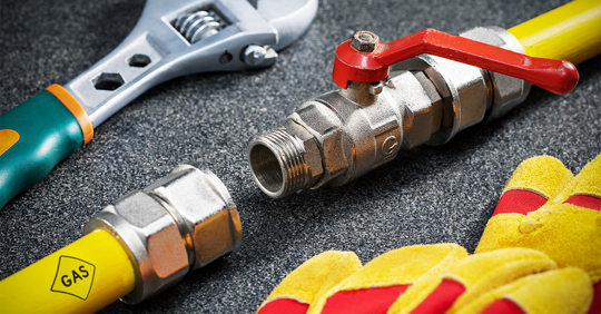 yellow gas pipe, wrench and protective gloves