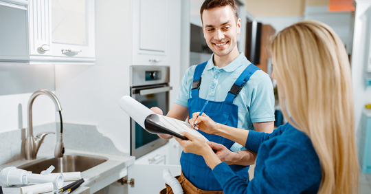 plumber and female customer in the kitchen
