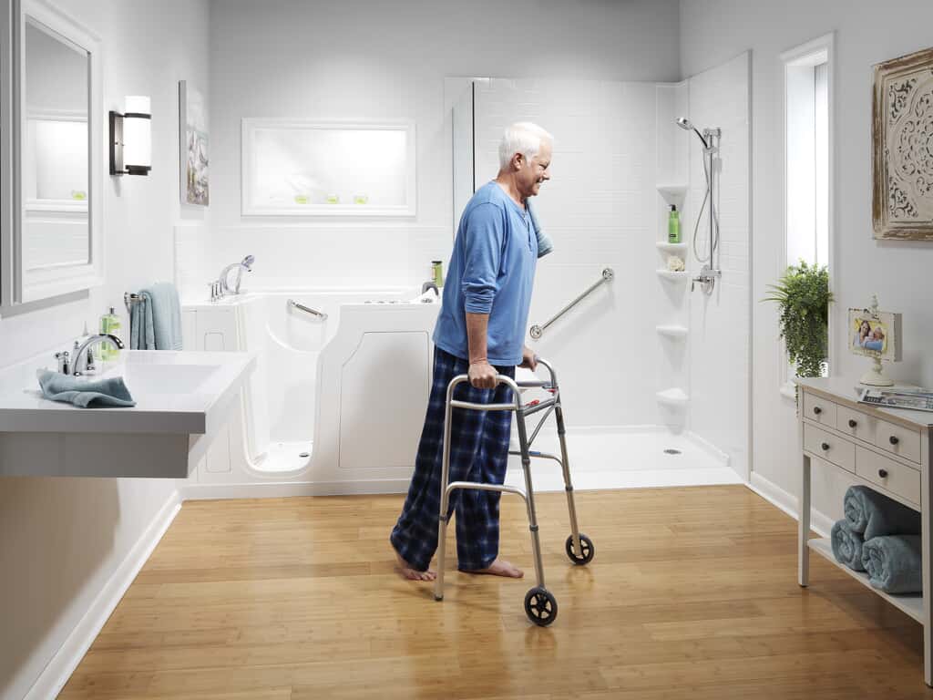 Elderly person on walker waking by bathtub